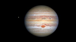 Image of Jupiter shows bands of orange and yellow sweeping across the surface with a distinctive big red spot in the clouds.